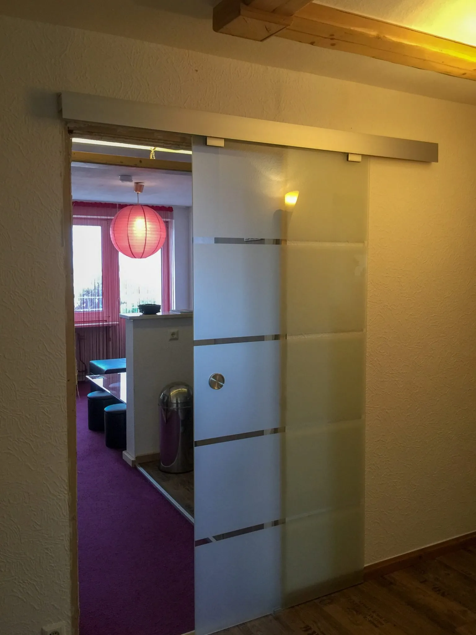 Glasschiebetür zwischen Flur und Wohnbereich