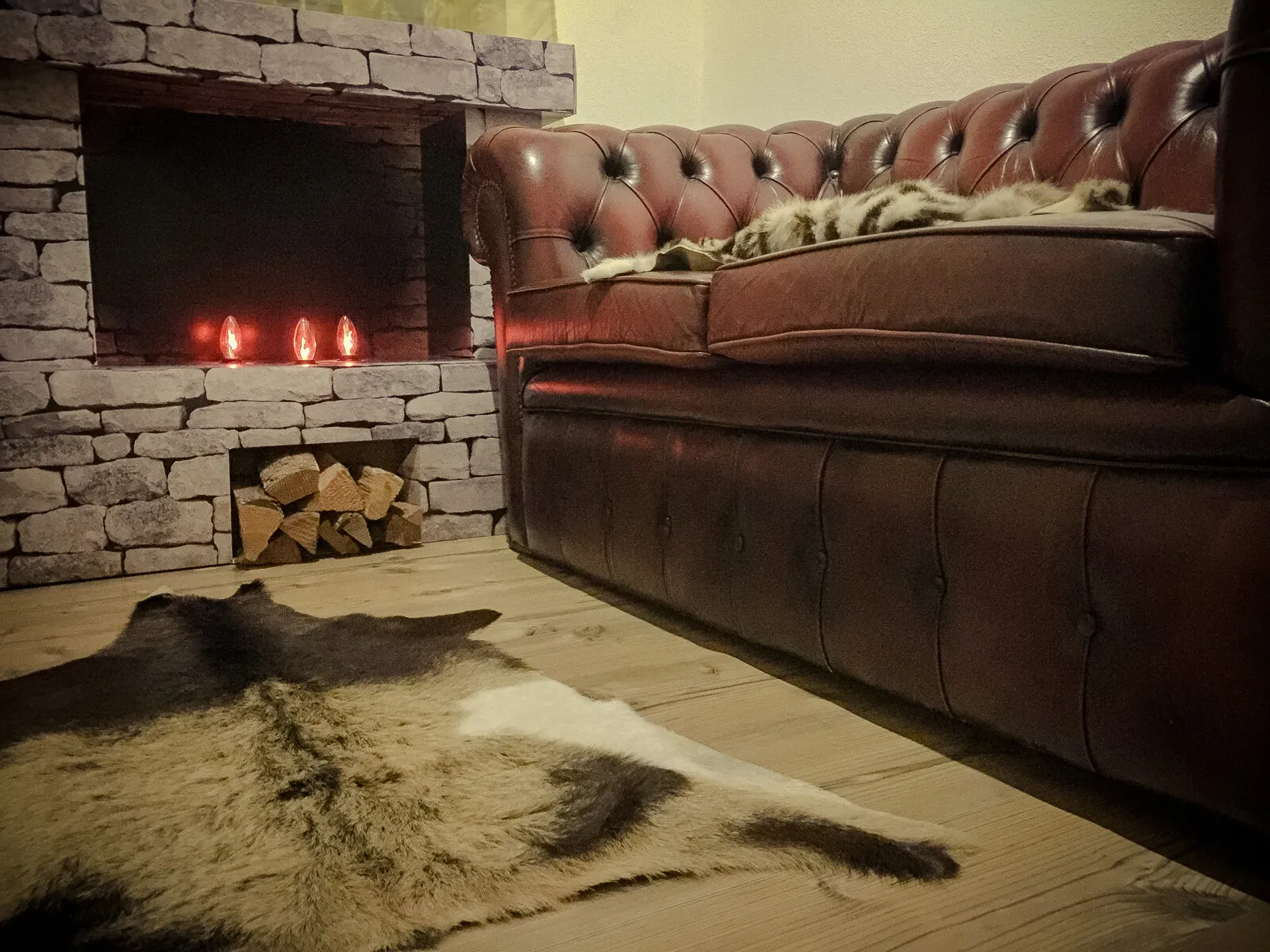 Chesterfield-Sofa vor dem Kamin mit Fell