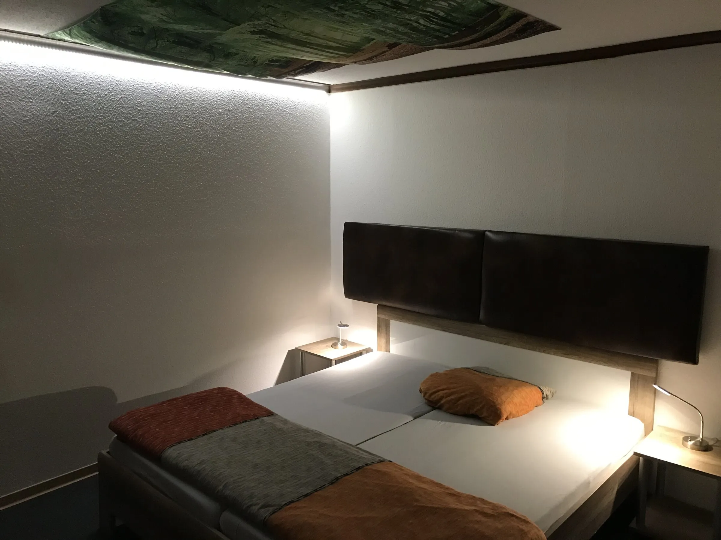 Schlafzimmer mit Doppelbett und Lichtdecke