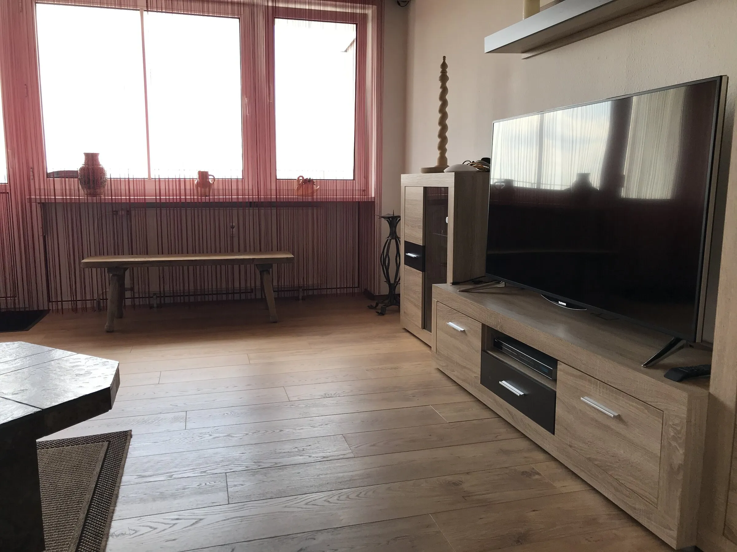 Wohnzimmer mit Smart-TV und Sideboard